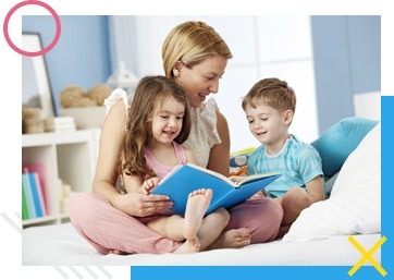 Mother reading a storybook to a young boy and girl on bed – educational bonding moment at Mini Marvels Emporium, baby and kids store in UAE