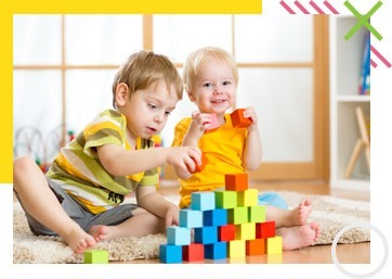 Two toddlers playing with colorful building blocks – baby and kids store in UAE