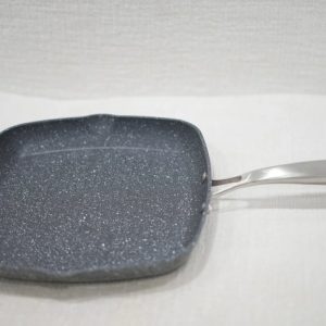 Close-up of square, dark grey, granite-look non-stick grill pan with a polished stainless steel handle.